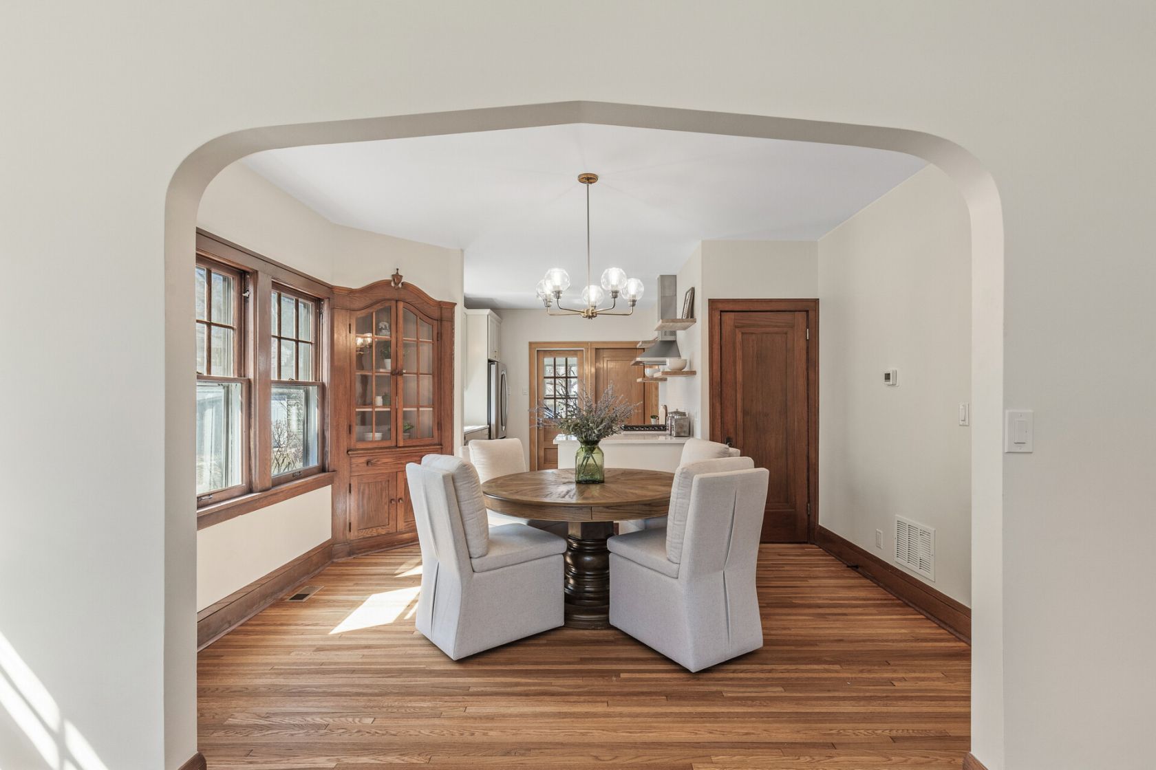 Dining room framed by original arched opening with built-in hutch