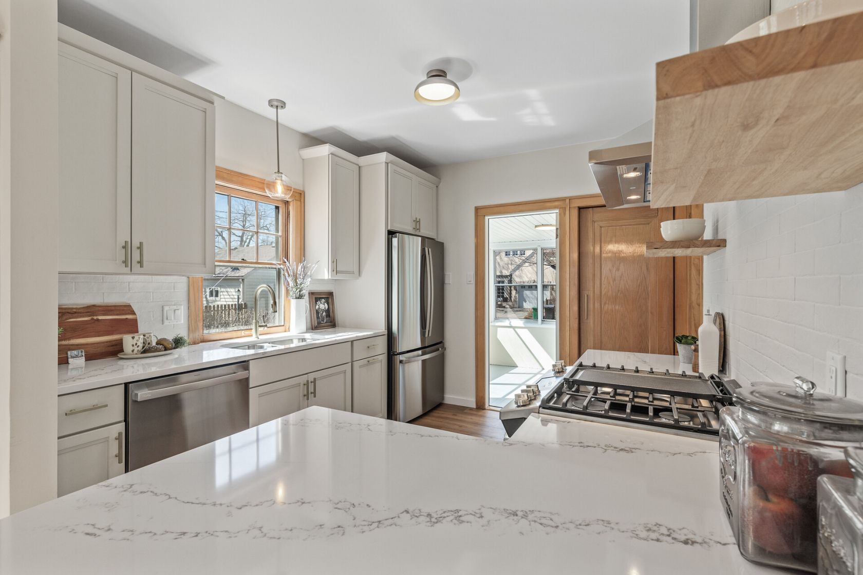 Quartz island with gas cooktop opening to sun porch